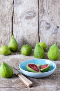 Still life with fresh green figs on old wood Still life with fresh green figs on old wood